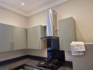 达灵顿Levy Nook 4的厨房配有白色橱柜和炉灶烤箱。