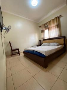 NamugongoTwinkle Blue Inn的一间卧室配有一张床和一把椅子