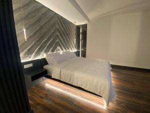 地拉那Tirana Central Rooms的一间卧室设有一张床和一个大石墙