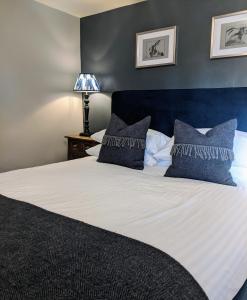 Quenington守护者臂弯宾馆的一间卧室配有一张带蓝色墙壁的大床