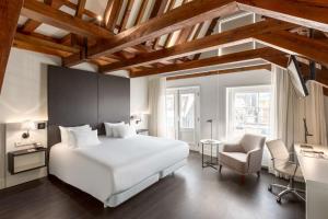 阿姆斯特丹阿姆斯特丹巴比松宫NH酒店的卧室配有一张白色大床和一把椅子