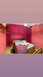 弗雷谢拉斯Vila Alicia Flecheiras的卧室设有粉红色的墙壁和一张大床