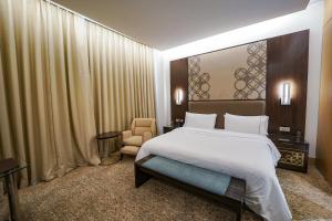 加尔各答加尔各答威斯汀酒店的卧室配有一张白色大床和一把椅子