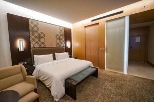 加尔各答加尔各答威斯汀酒店的一间卧室配有一张床、一张沙发和一把椅子