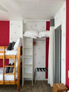 滨海拉特朗什金佩蒂特邦赫酒店的卧室配有两张双层床,拥有红色和白色的墙壁