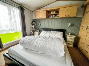 大雅茅斯Great 6 Berth Spacious Caravan With Large Outdoor Space Ref 50056l的一间卧室配有一张带白色床单的床和一扇窗户。