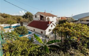 赫尔采格诺维Pet Friendly Apartment In Herceg Novi With Wifi的一座白色房子,在游泳池旁边设有红色屋顶