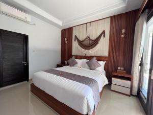 ToyapakehGrand Yuna Hotel Nusa Penida的一间卧室设有一张大床和一个窗户。
