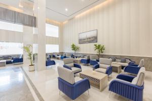麦地那فندق بلينسية Balensia Hotel的一间设有蓝色椅子和桌子的等候室