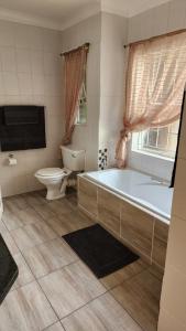 莫迪默勒SABLE INN B&B的带浴缸、卫生间和盥洗盆的浴室