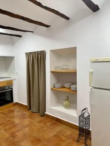 HinojaresCasa Rural Caballeriza的厨房配有冰箱和带餐具的架子
