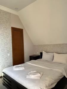 第比利斯7客房酒店的一间卧室配有带毛巾的床