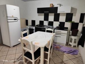 托雷斯Residencial Ramos的厨房配有冰箱和桌椅