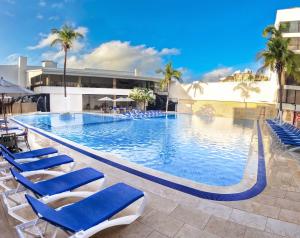 圣安德烈斯圣安德烈斯索尔加勒比全包式酒店的一个带蓝色椅子和棕榈树的大型游泳池