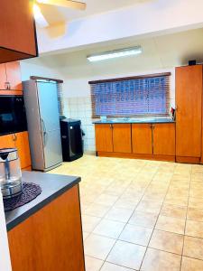 恩潘盖尼Listos Guest House的一个带木制橱柜和冰箱的大厨房