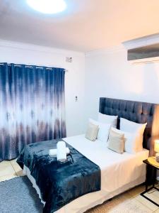 恩潘盖尼Listos Guest House的一间卧室配有一张蓝色窗帘的床