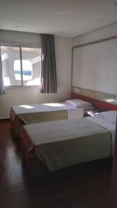 阿雷格里港维德斯帕萨罗斯阁楼中心酒店的酒店客房设有两张床和大窗户。