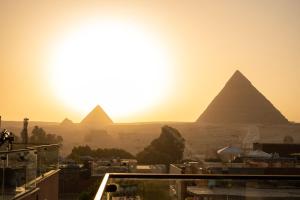开罗Sun and Sand Guest House的日落时分吉萨金字塔的景色