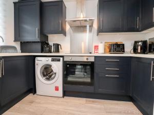 莫克姆3 Thrimby Court的厨房配有黑色橱柜和洗衣机。