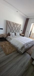 阿加迪尔Appartement 5 etoiles agadir vue mer的一间卧室配有一张大床和大床头板