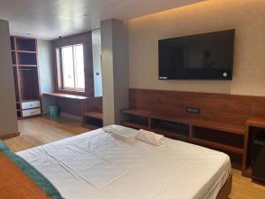 BrahmapurV HOTEL的一间卧室配有一张床和一台平面电视