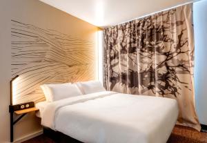 贝桑松B&B HOTEL Besançon Valentin的卧室配有白色的床和墙壁