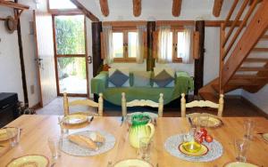 圣海梅-德恩韦哈Barraca típica del Delta, con piscina, jardín y barbacoa - Deltavacaciones的一张桌子,桌子上有面包,一张绿色的沙发在房间里