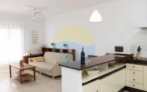 安波拉Baconer - Casa en l'Ampolla con jardín privado y acceso directo al mar - Deltavacaciones的厨房以及带沙发和桌子的客厅。