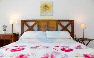 安波拉Baconer - Casa en l'Ampolla con jardín privado y acceso directo al mar - Deltavacaciones的卧室配有一张挂着花卉图案的床。