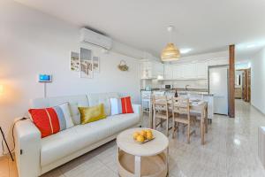 厄尔梅达诺Petite Homes Beach的客厅配有白色的沙发和桌子