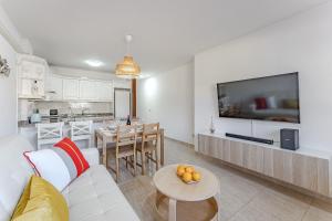 厄尔梅达诺Petite Homes Beach的一间带白色沙发的客厅和一间厨房