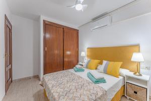厄尔梅达诺Petite Homes Beach的一间卧室配有黄色和蓝色枕头的床