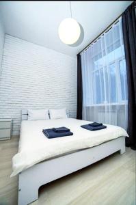 波尔塔瓦Atlas Hotel的配有大窗户的客房内的白色床