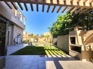 马拉喀什Marrakech Villa du Golfeur familles uniquement的后院设有带草坪的庭院