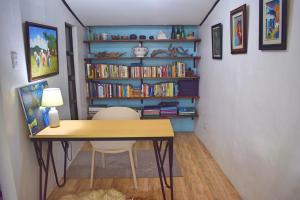 伊洛伊洛Cozy 1-bedroom house in quiet residential village.的一间设有书桌的客房和书架