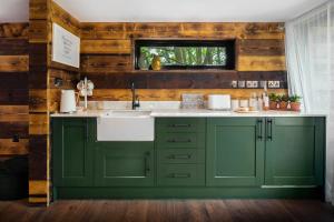 拉尔沃思湾石灰石酒店的厨房配有绿色橱柜和水槽