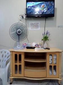 马六甲Thian Siong Inn的一张带风扇的桌子和一台墙上的电视