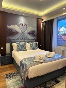 埃讷安hotel whiteswan的卧室配有一张床铺,墙上挂着两个天鹅