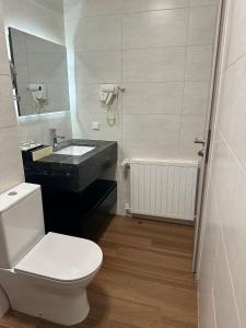 埃讷安hotel whiteswan的浴室配有卫生间、盥洗盆和浴缸。