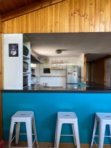 圣地亚哥Casa en Santiago equipada的厨房里的一个蓝色的柜台,有两张凳子