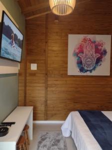 卡内拉Morada Bem Me Quer的一间卧室设有木墙、一张床和电视。
