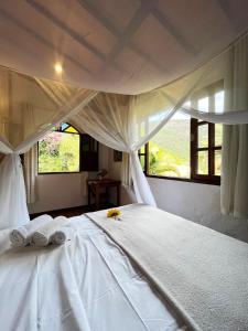 韦尔卡鲍Pousada do Capão Chapada Diamantina的卧室配有白色床和毛巾