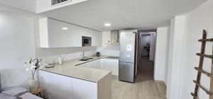 阿尔么丽亚AlmeriaSuite City Centre的厨房配有白色橱柜和不锈钢冰箱