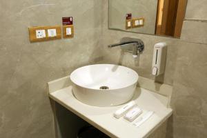 古尔冈Hotel Sakura by Maps的浴室设有白色水槽和镜子