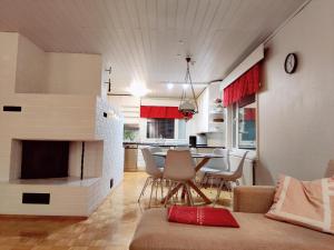 库萨莫Tilava asunto saunalla的客厅设有壁炉、桌子和椅子