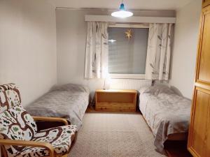 库萨莫Tilava asunto saunalla的一间卧室设有两张床、一个窗口和椅子