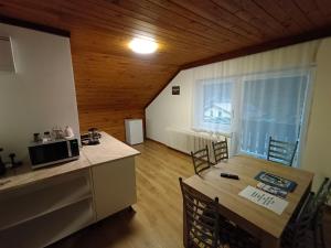 穆劳Müller Apartment的厨房设有木制天花板和桌椅