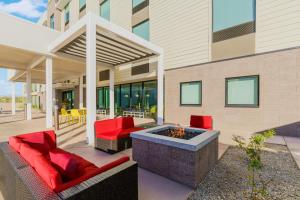 玛丽湖Home2 Suites By Hilton Lake Mary Orlando的一个带红色椅子和火坑的庭院