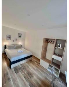 加普Appartement chaleureux en hyper centre de Gap的一间卧室配有一张床,铺有木地板