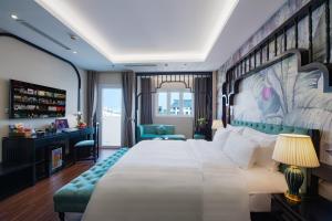河内PALAGO BOUTIQUE HOTEL的酒店客房设有一张大床和一张书桌。